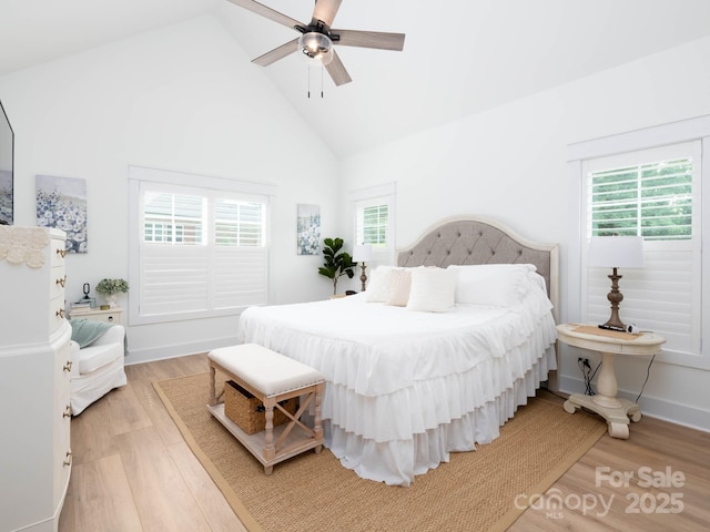 bedroom featuring multiple windows, light wood finished floors, high vaulted ceiling, and ceiling fan