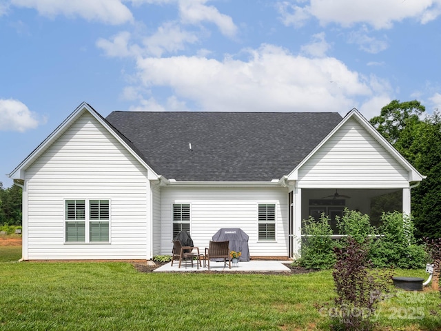back of property featuring a ceiling fan, a patio area, roof with shingles, and a lawn
