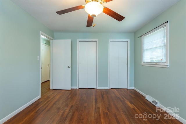 49 Jeffress Ave, Asheville, NC 28803 - unfurnished bedroom with two closets, dark wood-style floors, and a ceiling fan