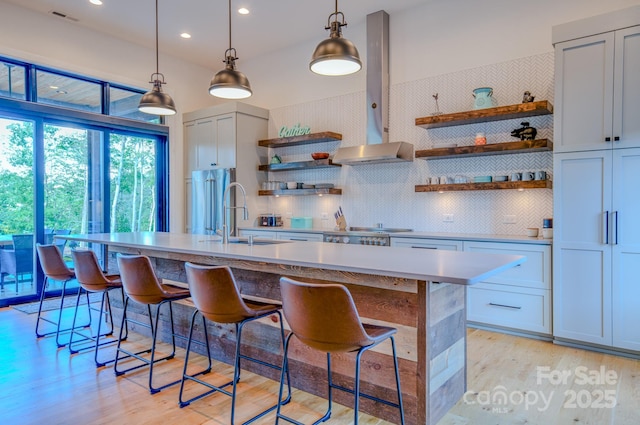 223 Linville View Dr, Nebo, NC 28761 - kitchen featuring open shelves, a sink, light wood-style floors, wall chimney range hood, and a kitchen breakfast bar