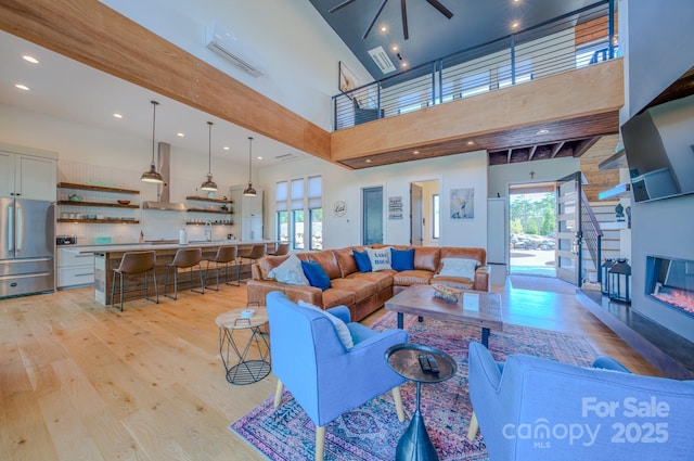 223 Linville View Dr, Nebo, NC 28761 - living room featuring light wood-style floors, a towering ceiling, a glass covered fireplace, recessed lighting, and a ceiling fan
