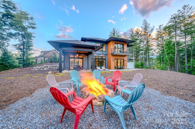223 Linville View Dr, Nebo, NC 28761 - back of property at dusk with an outdoor fire pit, a balcony, french doors, and a patio area