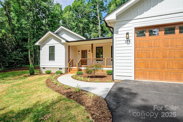 118 W Laurel Ln, Etowah, NC 28729 - view of front of house with board and batten siding, covered porch, an attached garage, a front lawn, and crawl space