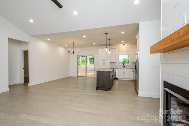 118 W Laurel Ln, Etowah, NC 28729 - kitchen featuring stainless steel fridge, a kitchen island, a fireplace, light wood-style floors, and recessed lighting