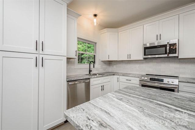118 W Laurel Ln, Etowah, NC 28729 - kitchen featuring stainless steel appliances, backsplash, white cabinetry, and light stone countertops