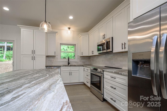 118 W Laurel Ln, Etowah, NC 28729 - kitchen featuring appliances with stainless steel finishes, decorative backsplash, white cabinets, recessed lighting, and pendant lighting
