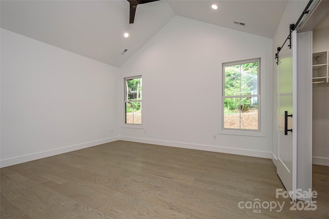 118 W Laurel Ln, Etowah, NC 28729 - spare room with a barn door, high vaulted ceiling, recessed lighting, and wood finished floors
