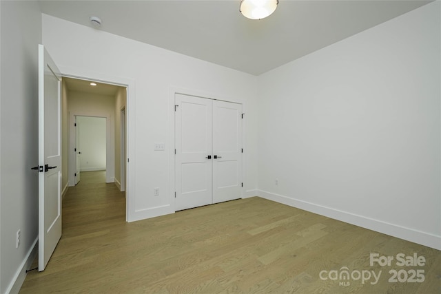 118 W Laurel Ln, Etowah, NC 28729 - unfurnished bedroom featuring light wood-type flooring and a closet