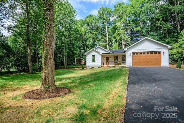 118 W Laurel Ln, Etowah, NC 28729 - ranch-style house featuring covered porch, driveway, a front lawn, and a garage