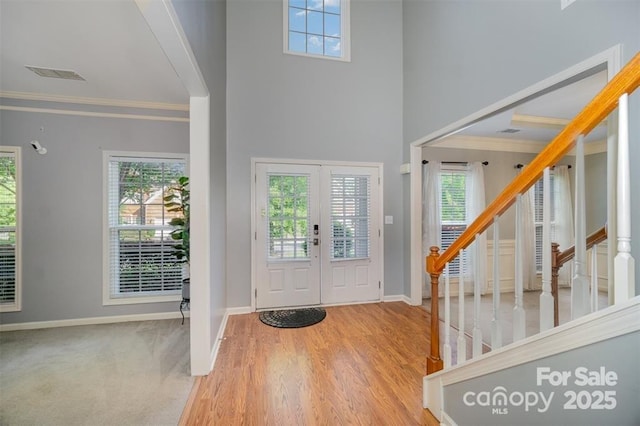 10515 Greenhead View Rd, Charlotte, NC 28262 - foyer with crown molding, baseboards, stairway, wood finished floors, and a towering ceiling