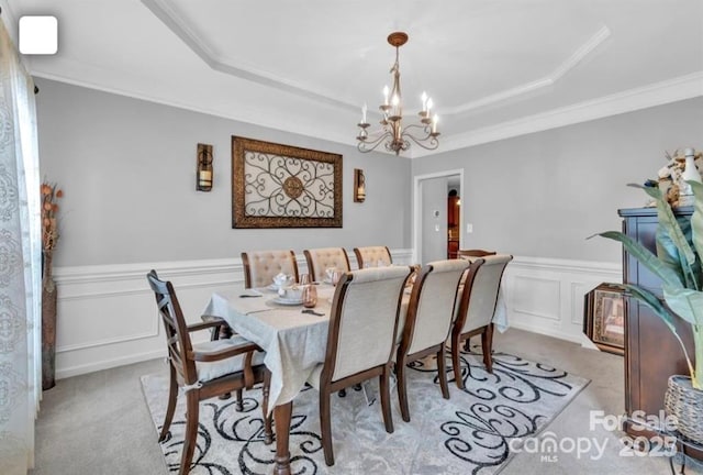 10515 Greenhead View Rd, Charlotte, NC 28262 - dining area featuring a tray ceiling, a chandelier, light carpet, wainscoting, and a decorative wall