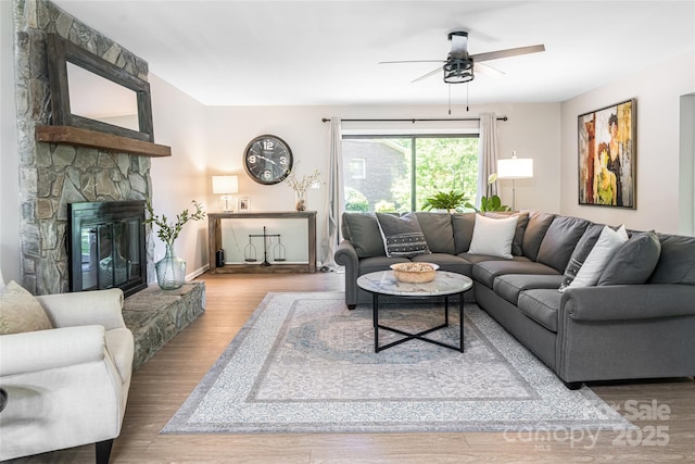 16 Royal Rdg, Clyde, NC 28721 - living room featuring a ceiling fan, wood finished floors, a stone fireplace, and baseboards
