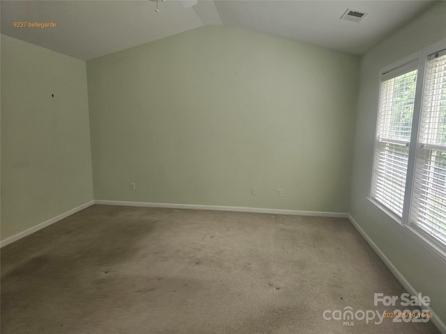 carpeted empty room featuring baseboards, lofted ceiling, and ceiling fan