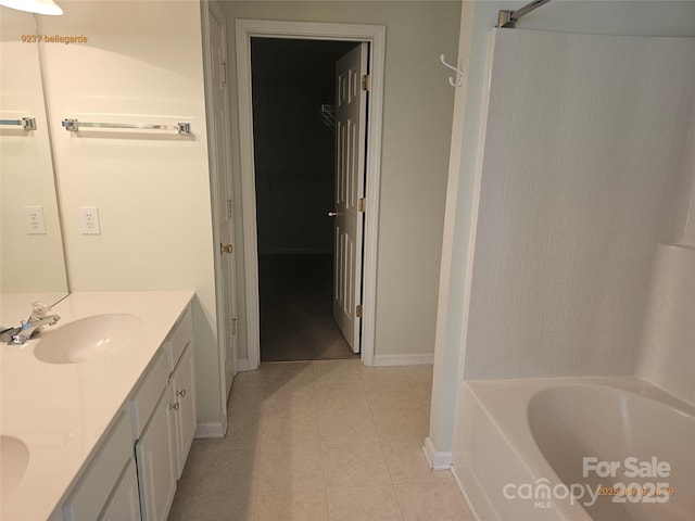 bathroom with tile patterned flooring, baseboards, double vanity, and shower / tub combination