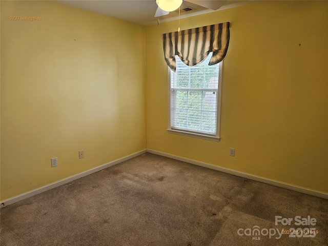 unfurnished room featuring carpet floors, a ceiling fan, and baseboards