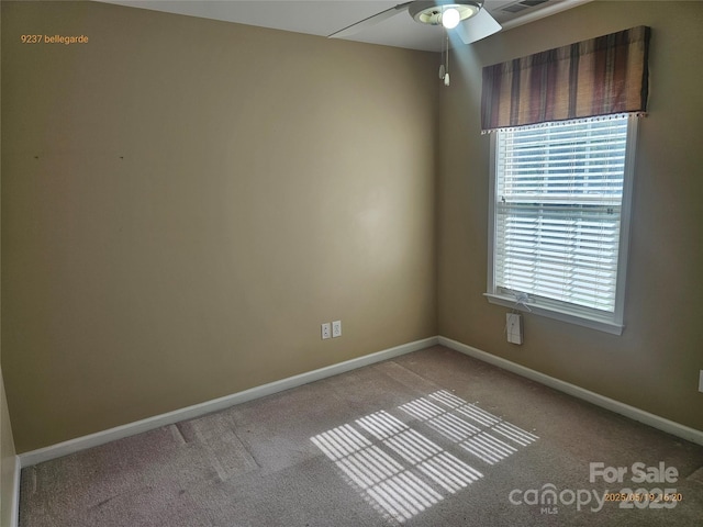 carpeted empty room with a ceiling fan and baseboards