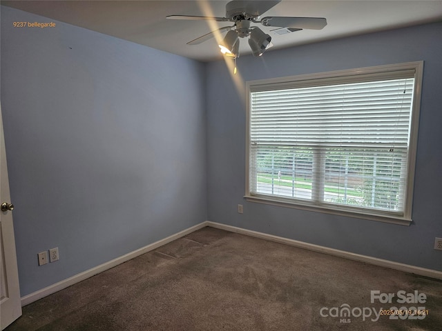 carpeted spare room with ceiling fan and baseboards