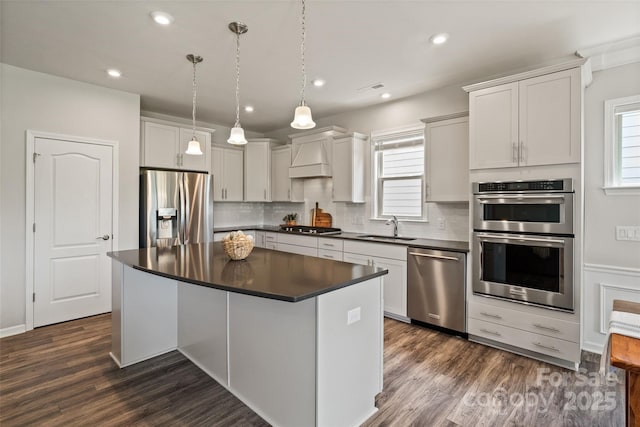 2329 Delaney Dr, Fort Mill, SC 29715 - kitchen with appliances with stainless steel finishes, dark countertops, a center island, tasteful backsplash, and dark wood-style flooring