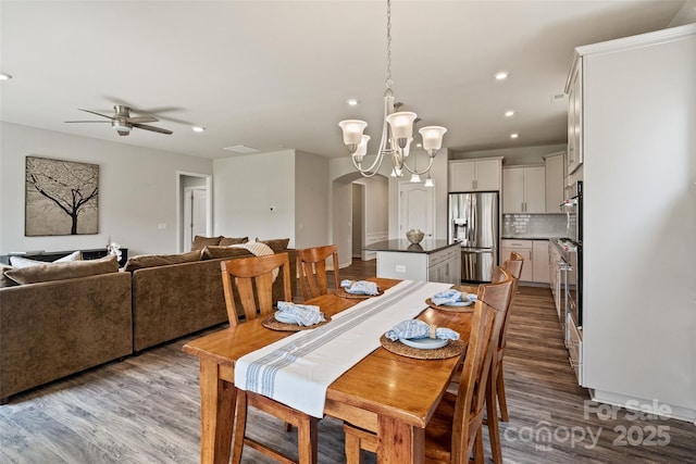 2329 Delaney Dr, Fort Mill, SC 29715 - dining room with arched walkways, wood finished floors, recessed lighting, a ceiling fan, and a chandelier