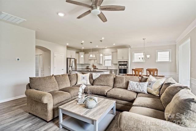 2329 Delaney Dr, Fort Mill, SC 29715 - living area featuring arched walkways, wood finished floors, a ceiling fan, recessed lighting, and crown molding