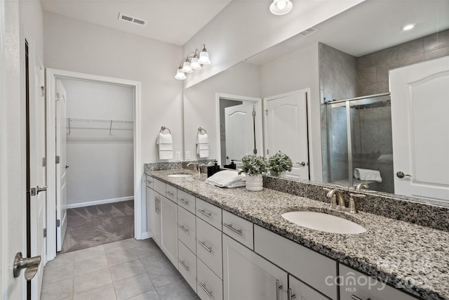 2329 Delaney Dr, Fort Mill, SC 29715 - bathroom with double vanity, a shower stall, a spacious closet, tile patterned flooring, and baseboards
