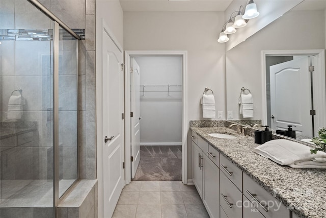 2329 Delaney Dr, Fort Mill, SC 29715 - bathroom featuring a shower stall, vanity, tile patterned flooring, a spacious closet, and baseboards