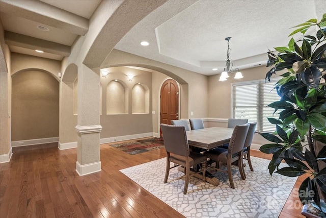 1974 Glen Manor Ct, Lincolnton, NC 28092 - dining room featuring arched walkways, wood-type flooring, baseboards, a chandelier, and a textured ceiling