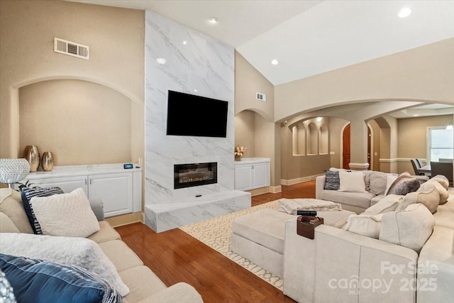 1974 Glen Manor Ct, Lincolnton, NC 28092 - living room with arched walkways, wood finished floors, high vaulted ceiling, a premium fireplace, and recessed lighting
