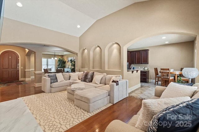 1974 Glen Manor Ct, Lincolnton, NC 28092 - living area featuring arched walkways, baseboards, light wood finished floors, vaulted ceiling, and recessed lighting