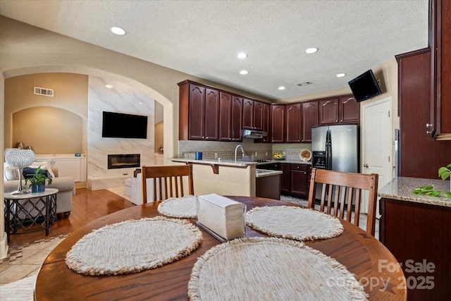 1974 Glen Manor Ct, Lincolnton, NC 28092 - dining room featuring recessed lighting, a fireplace, a textured ceiling, and arched walkways