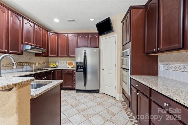1974 Glen Manor Ct, Lincolnton, NC 28092 - kitchen with appliances with stainless steel finishes, under cabinet range hood, dark brown cabinets, light stone counters, and recessed lighting