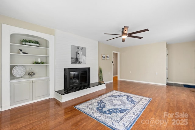 220 Pinehurst Ln, Newton, NC 28658 - unfurnished living room with a large fireplace, a ceiling fan, wood finished floors, and built in shelves