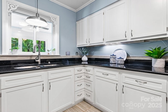 220 Pinehurst Ln, Newton, NC 28658 - kitchen featuring a sink, ornamental molding, white cabinets, dark stone counters, and pendant lighting