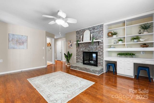 220 Pinehurst Ln, Newton, NC 28658 - living room with ceiling fan, dark wood-type flooring, baseboards, and a brick fireplace