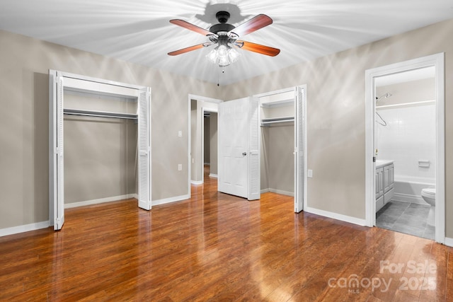 220 Pinehurst Ln, Newton, NC 28658 - unfurnished bedroom with two closets, wood finished floors, connected bathroom, ceiling fan, and baseboards