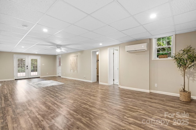 220 Pinehurst Ln, Newton, NC 28658 - unfurnished living room featuring a wall mounted AC, wood finished floors, baseboards, french doors, and a drop ceiling