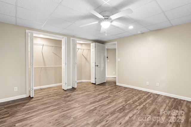 220 Pinehurst Ln, Newton, NC 28658 - unfurnished bedroom with wood finished floors, a drop ceiling, baseboards, ceiling fan, and two closets