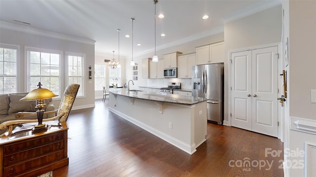 123 Hanks Bluff Dr, Mooresville, NC 28117 - kitchen featuring appliances with stainless steel finishes, a breakfast bar area, dark stone countertops, dark wood-style flooring, and ornamental molding
