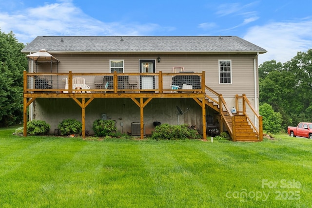 rear view of property featuring a wooden deck, stairway, and a yard