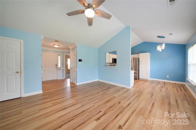 unfurnished living room with light wood finished floors, a ceiling fan, a chandelier, lofted ceiling, and baseboards