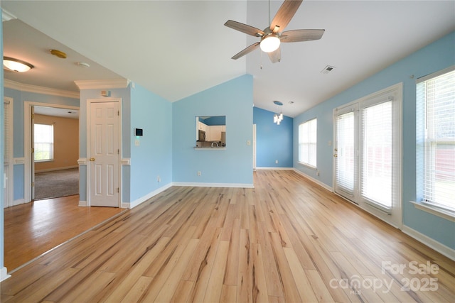 unfurnished living room featuring light wood finished floors, ceiling fan, baseboards, plenty of natural light, and crown molding