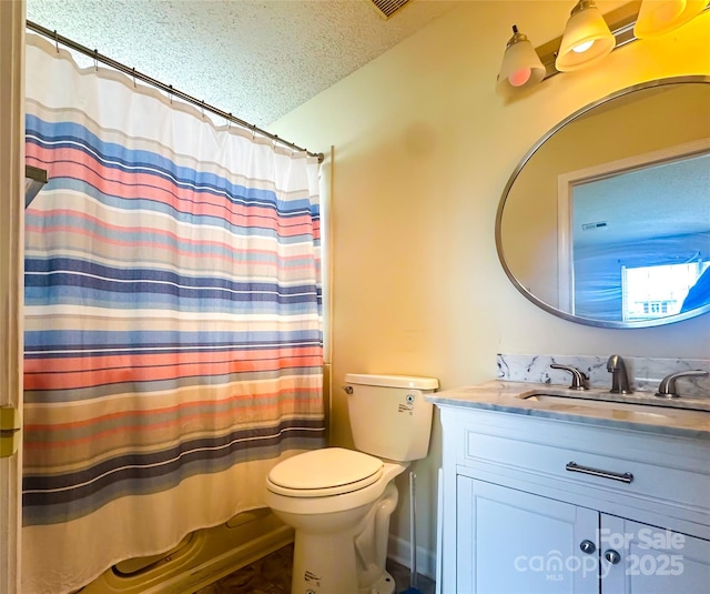 bathroom with vanity, toilet, and a textured ceiling