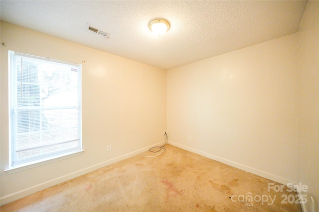 unfurnished room featuring light colored carpet and baseboards