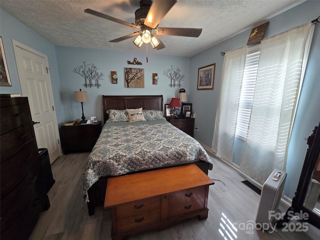 490 Deberry Rd, Mount Gilead, NC 27306 - bedroom featuring a textured ceiling, light wood-type flooring, and a ceiling fan