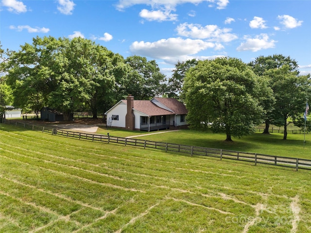 view of yard with an outdoor structure and a rural view