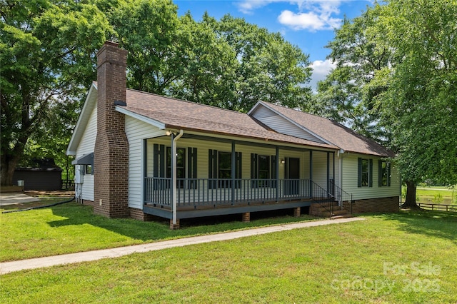 view of front of property with a porch, a front yard, a chimney, and roof with shingles