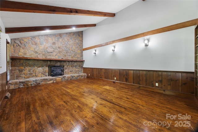 unfurnished living room with wainscoting, wood-type flooring, and wooden walls