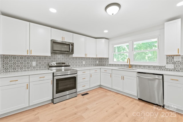 518 Westside Cir, China Grove, NC 28023 - kitchen featuring stainless steel appliances, a sink, light countertops, light wood finished floors, and recessed lighting