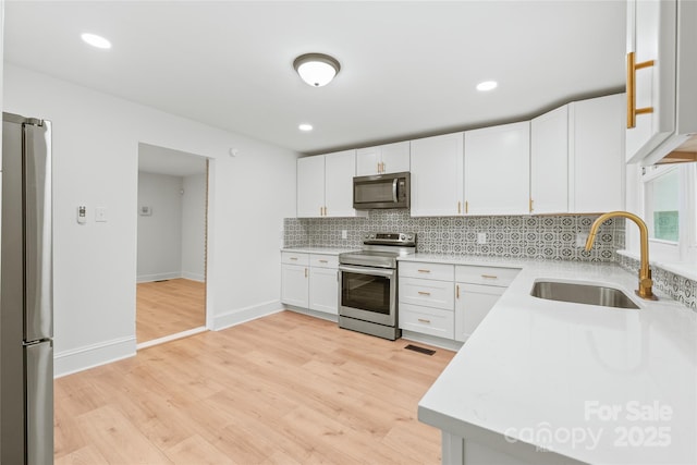 518 Westside Cir, China Grove, NC 28023 - kitchen featuring stainless steel appliances, a sink, tasteful backsplash, light countertops, and baseboards