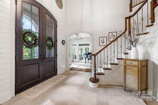 5523 Meadow Haven Ln, Charlotte, NC 28270 - entryway with a chandelier, stairway, arched walkways, a high ceiling, and wood walls